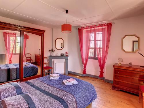 a bedroom with a bed and a dresser and two windows at Ferme Gascone proche Marciac in Bars