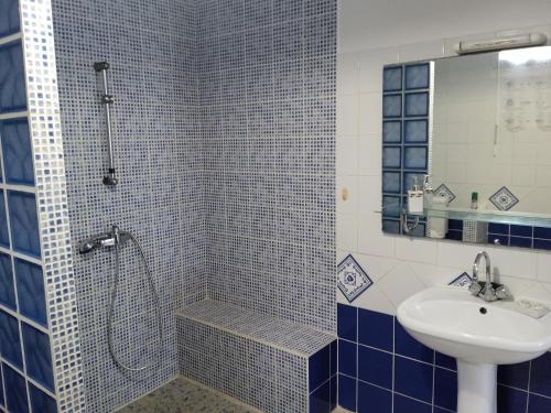 y baño azul y blanco con ducha y lavabo. en ZEN SOUFRIERE, en Saint-Claude