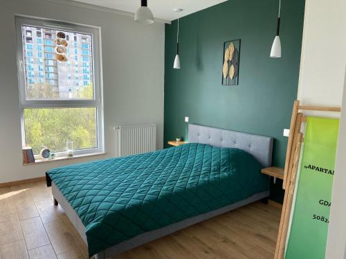1 dormitorio con 1 cama verde y 2 ventanas en Apartament Nina, en Gdansk