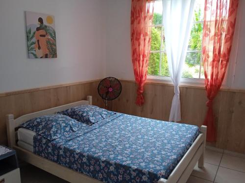 a bedroom with a bed and a window at ZEN SOUFRIERE in Saint-Claude