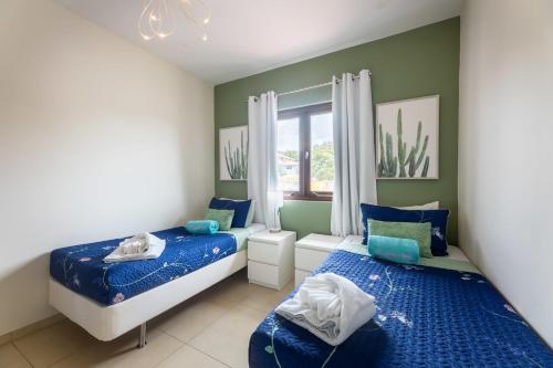 Dorp Sint Michiel的住宿－Green View at Blue Bay Golf & Beach Resort，一间卧室设有两张床和窗户。