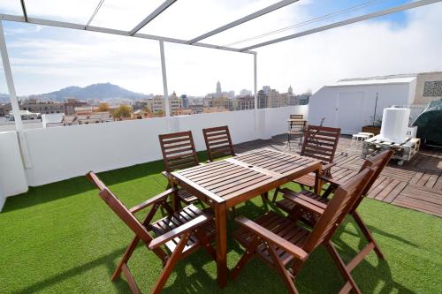 een patio met een tafel en stoelen op een dak bij Letmalaga Malasaña City Views Superior Apartment in Málaga