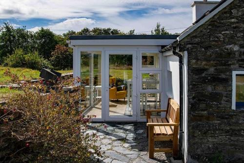 an orangerie with a conservatory in a garden at Gemütliches Cottage mit Meerblick in Béal an dá Chab