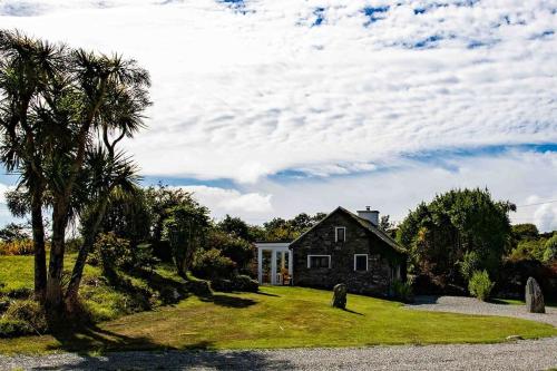a house sitting on top of a lush green field at Gemütliches Cottage mit Meerblick in Ballydehob