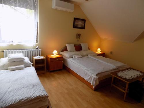 a bedroom with two beds and a window at Charlie Vendégház,emelet 8 fős,100m2-es apartman in Siófok