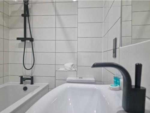 a bathroom with a tub and a sink and a shower at IR Benfleet south in South Benfleet