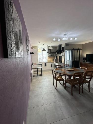 une cuisine et une salle à manger avec une table et des chaises dans l'établissement Maison près de la ville, à Saint-Étienne-au-Mont