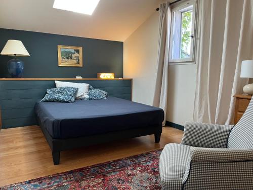 une chambre avec un lit, une chaise et une fenêtre dans l'établissement Maison de charme avec piscine, à Saint-Martin-de-Seignanx