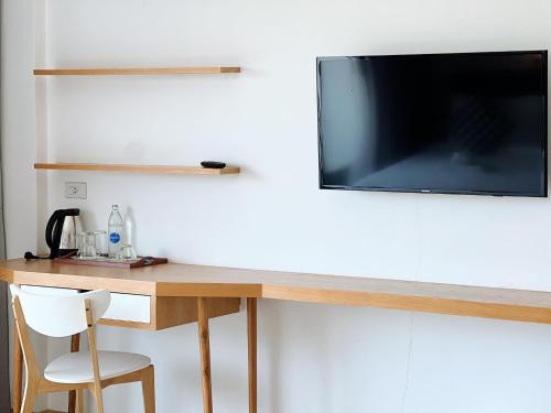 a desk with a television on a wall at Phukaning in Udon Thani