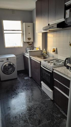 uma cozinha suja com um fogão e uma máquina de lavar roupa em Abasto Lindo Dpto 2 Amb c Cocina Mantenemos Precio em Buenos Aires