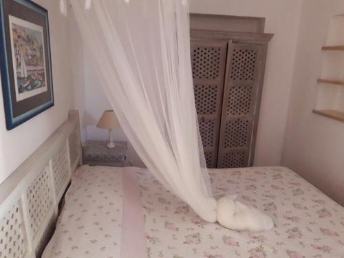 a bedroom with a bed with a curtain at Aura - Le due Lune in Lampedusa