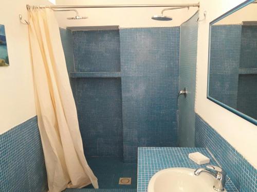 a bathroom with a sink and a shower with a shower curtain at Aura - Le due Lune in Lampedusa