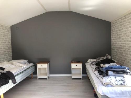 Zimmer mit 2 Betten und 2 Nachttischen in der Unterkunft Lugnet in Hörby