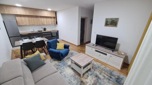 un soggiorno con divano e tavolo e una cucina di Apartman Centar Bečej a Bečej