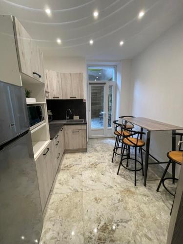 - une cuisine avec une table, des chaises et un comptoir dans l'établissement Appartement centre-ville, à Alès