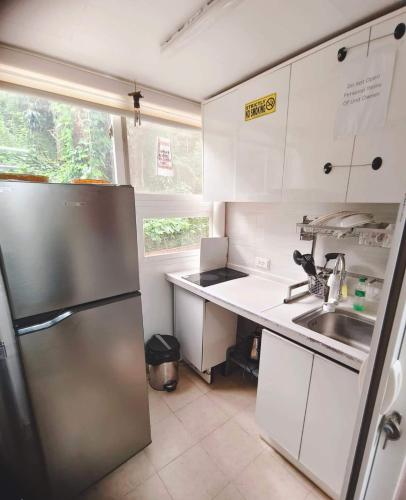 a kitchen with a stainless steel refrigerator and a sink at Zenmist Properties- 2 Bedroom Deluxe in Baguio