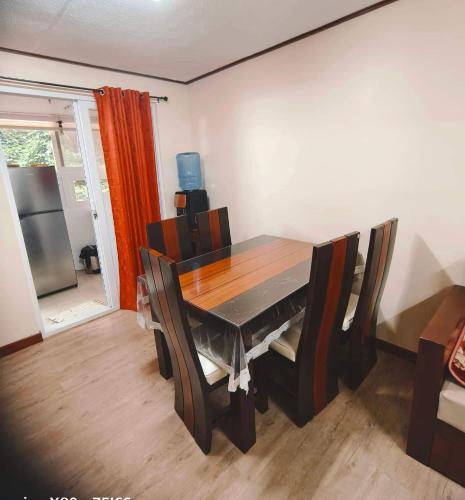 a dining room with a wooden table and chairs at Zenmist Properties- 2 Bedroom Deluxe in Baguio