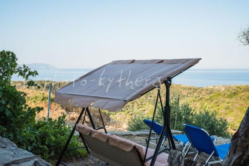 a group of chairs and an umbrella on a hill at Two little houses with panorama view in Kýthira