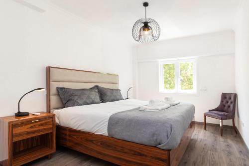 um quarto com uma cama grande e uma cadeira em Cascais Duplex Apartment em Cascais