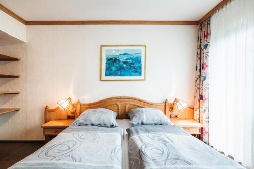 a bedroom with two beds and a window at Landhotel Alte Aue in Altenau