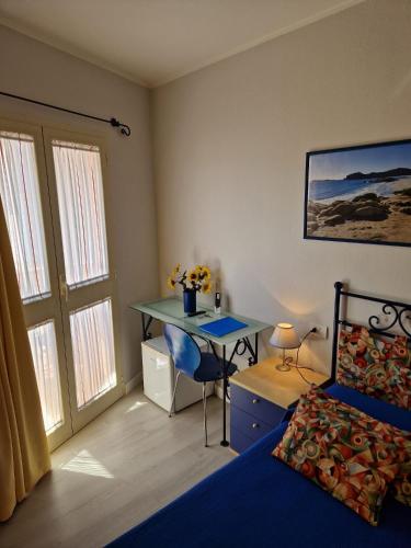 a bedroom with a bed and a desk and a bed at Ca'Mea in Villasimius