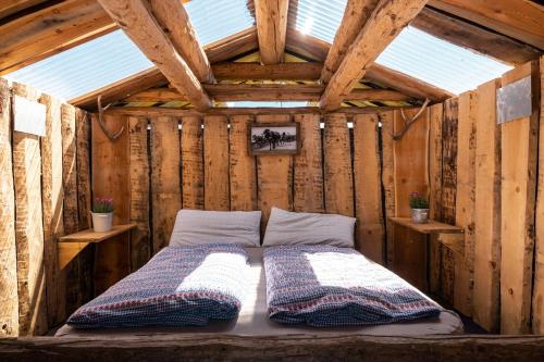 a bed in the middle of a wooden house at Tgamon Somtgant mit Glasdach in Malmigiuer