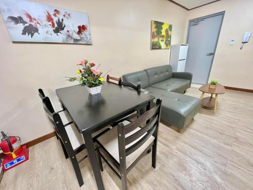 a living room with a table and a couch at Zenmist Properties- 2 Bedroom Deluxe in Baguio