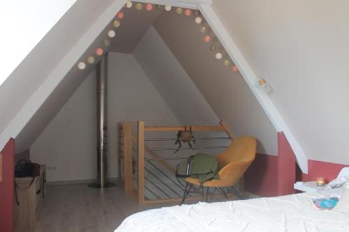 a bedroom with a bed and a chair in a attic at Happy & Relax in Mentque-Nortbécourt