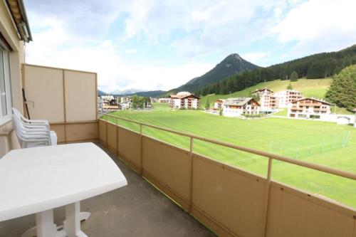 a balcony with a table and a soccer field at Apartment Bünda in Davos