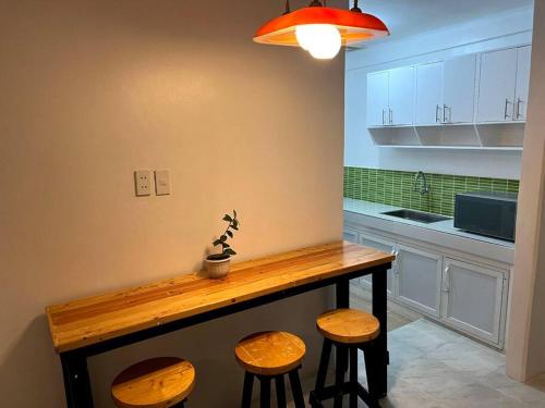 - une cuisine avec une table en bois et des tabourets dans l'établissement Affordable 3 Bedroom Lodge (Free Wi-Fi + Netflix), à Ángeles