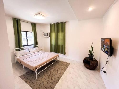 - une chambre avec un lit dans une pièce dotée de rideaux verts dans l'établissement Affordable 3 Bedroom Lodge (Free Wi-Fi + Netflix), à Ángeles