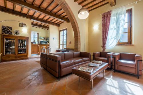 a living room with leather furniture and a table at Boccioleto Resort - Place of Charme in Montaione