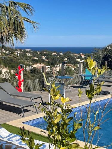 - une piscine avec des chaises et une vue sur l'océan dans l'établissement Villa de qualité vue mer piscine chauffée, à Roquebrune-sur Argens