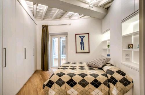 - une chambre avec un lit et une couverture en damier dans l'établissement suity I cozy leutari 23, à Rome