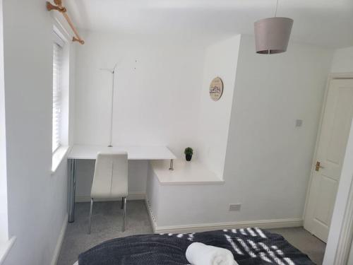 a white room with a white desk and a table at 2 Bedroom end of terrace house in Wellington