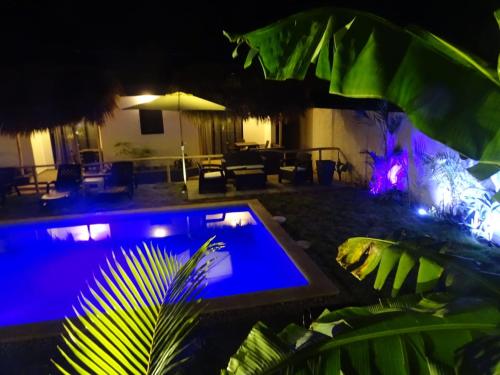 a swimming pool in a yard at night at BUNGALOWS COLIBRI in Las Galeras