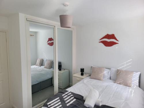 a white bedroom with a mirror and a bed at 2 Bedroom end of terrace house in Wellington
