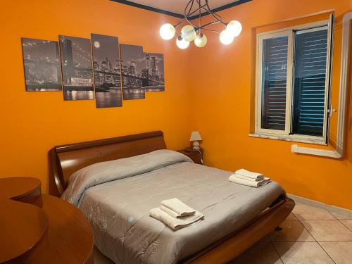 een slaapkamer met een bed met twee handdoeken erop bij Airport Tourist's Home in Catania