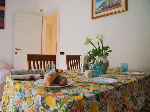 einen Tisch mit einem Tischtuch mit einem Teller Essen drauf. in der Unterkunft Holiday House Mentina in Minori
