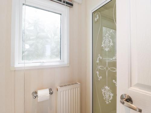 a bathroom with a toilet and a window and a radiator at Whiteside in Cockermouth