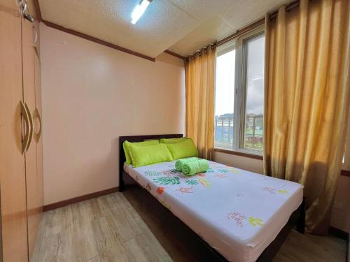 a small bedroom with a bed and a window at Zenmist Properties- 2 Bedroom Economy in Baguio