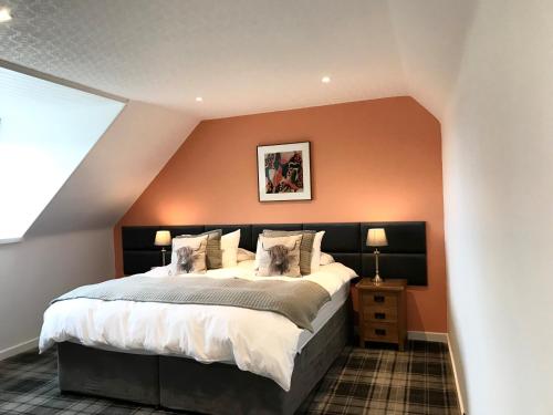 um quarto com uma cama grande e paredes cor-de-laranja em Meadhon Guest House em Jedburgh