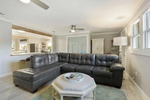 a living room with a leather couch and a table at Beautiful Beach House 2 Minute Walk to Sandy Beaches Quiet Area in Gulfport