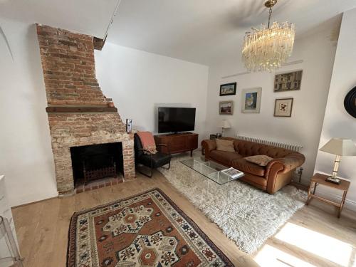 a living room with a couch and a fireplace at Close to Goodwood- Dogs Welcome -3 beds & Parking in Petworth