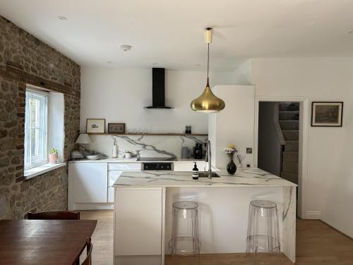 a kitchen with a white counter top and a table at Close to Goodwood- Dogs Welcome -3 beds & Parking in Petworth