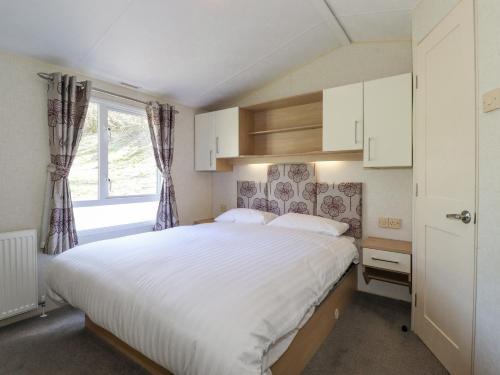 a bedroom with a large white bed and a window at Swinside in Cockermouth