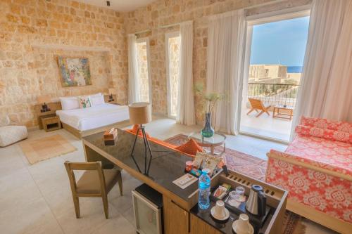 een woonkamer met een bank, een tafel en een woonkamer bij Wadi Sabarah Lodge in Marsa Alam