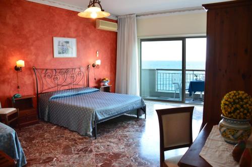 una camera da letto con un letto e vista sull'oceano di Costa Azzurra a Giardini Naxos