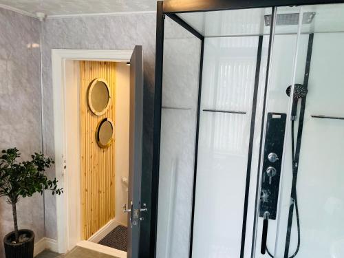 uma casa de banho com um chuveiro e uma porta amarela em Holywell Apartment - Luxury One Bedroom Apartment em Holywell