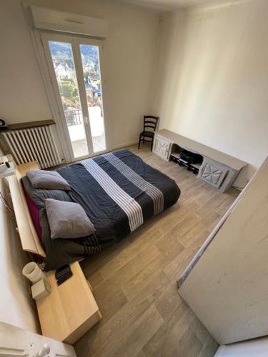une chambre avec un lit et une grande fenêtre dans l'établissement Balcon St Raymond maison 100m2 centre Lourdes, à Lourdes